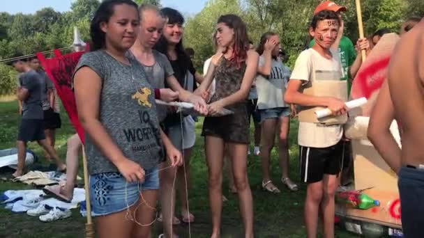 Korosten-srpen, 12, 2019: Skupina teenagerů stojí na břehu řeky a křičí před začátkem vodních sportů — Stock video
