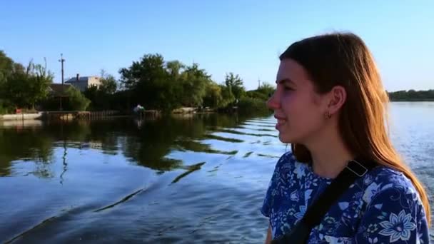 Güneşli bir günde genç bir kadın nehir veya göl üzerinde bir tekne sürmek. Kız bir tekneyle seyahat ediyor. Metin için kopyalama alanı ile yakın çekim — Stok video