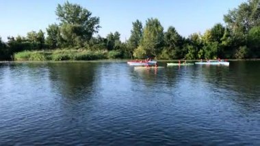 Kherson - 28 Ağustos 2019: Güzel nehirde kanoya binerken eğlenen dört genç yetişkinden oluşan bir grubun yakınlığı