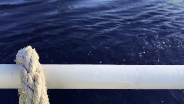 Close-up corda nó náutico amarrado em torno de estaca em barco ou navio, corda de ancoragem barco. Corda de fuzileiro no navio. O navio sai do porto. Farol. Corda de amarração . — Vídeo de Stock
