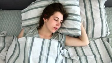 Güzel Genç Esmer Charmingly Sabahın Erken Saatlerinde Yatağında Uyur. Sakin uyuyan kızın tatlı ve sıcak görünümü
