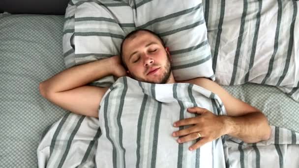 若い男のトップビューはベッドで眠っている. — ストック動画