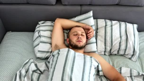 Top syn på ung man sover i sängen. — Stockvideo