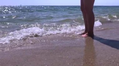 gün doğumunda deniz kenarında ayak sıçrayan plaj dalgaları üzerinde duran kadın ayakları yavaş hareket güzel su sahil görüntüleri