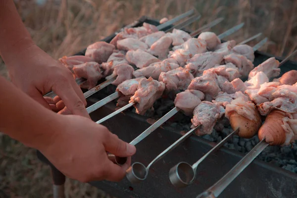 Man frying shish kebab on the grill. Hands closeup outdoors — Stock Photo, Image