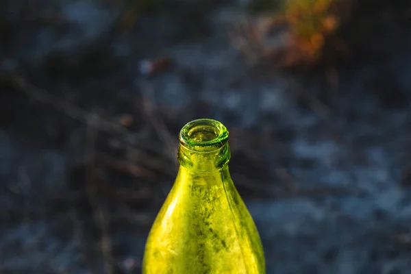 green dirty glass bottle close-up on a sunny day in nature