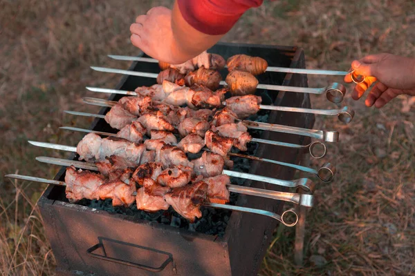 Man bakt shish kebab op de grill. Handen van dichtbij buiten. — Stockfoto