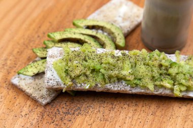 Avokado ve baharatlı ekmek, ahşap arka planda tost..