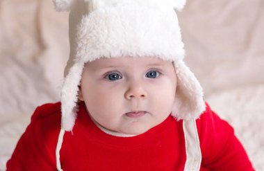 Noel çocuğu düşünceli, rüya gibi şaşırmış duygulardır. Kırmızı elbiseli ve beyaz şapkalı şirin küçük bir kız duygularını ifade ediyor. Arka planda küçük çocuk ağacı ve çelenk olan Noel konsepti bulanık