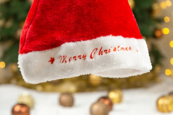 Noel Baba Şapkası Mutlu Noeller Yazılı Arka Planda Ağaç Çelenkler — Stok fotoğraf