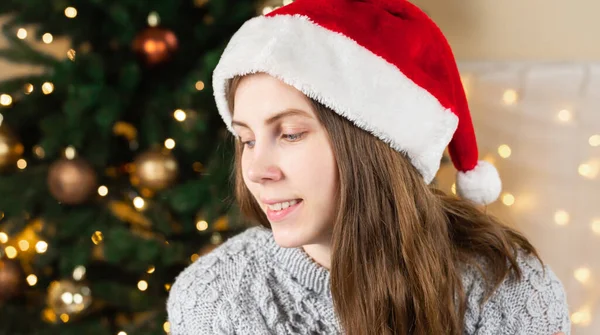 Retrato Una Mujer Joven Suéter Gris Sombrero Santa Claus Sienta — Foto de Stock