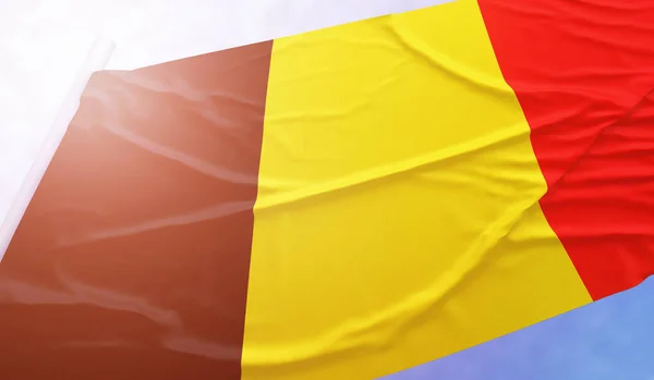 Belgische vlag aan de blauwe hemel. Sluit de nationale vlag in felle stralen zon die zwaait in de wind op vlaggenmast. — Stockfoto
