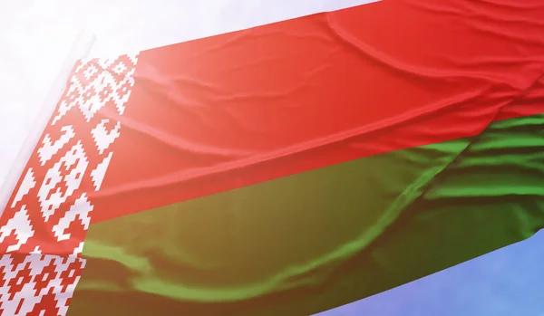 Fehérorosz zászló a kék égen. Zárja be a nemzeti zászlót fényes sugarak nap, amely integet a szél zászlórúd. — Stock Fotó
