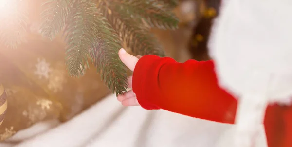 Kırmızı Elbiseli Bir Çocuğun Küçük Bebek Eli Noel Yılbaşı Ağacına — Stok fotoğraf