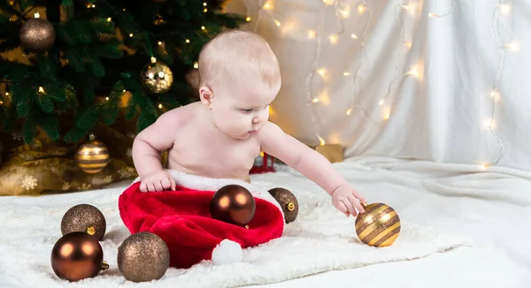 Urocze Dziecko Bez Ubrań Kapeluszu Świętego Mikołaja Tle Bożonarodzeniowych Kulek — Zdjęcie stockowe