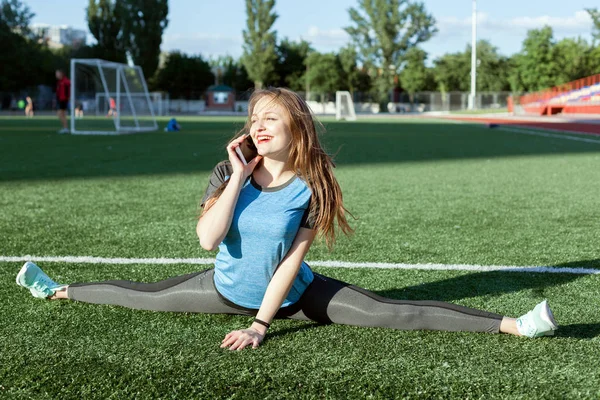 女性が電話で話しているし 競技場でスポーツをやって — ストック写真
