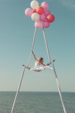 Kadın balonlar gökyüzünde yüksek uçan, o bir spor sicim sergiliyor.