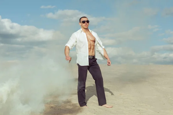 Männlicher Bodybuilder Steht Der Wüste Hält Eine Zigarre — Stockfoto