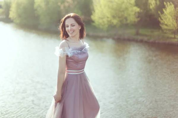 Vrouw in een paarse jurk is glimlachend. — Stockfoto