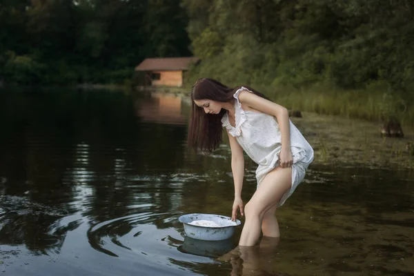 Young laundress stands in the river. — Stock Photo, Image