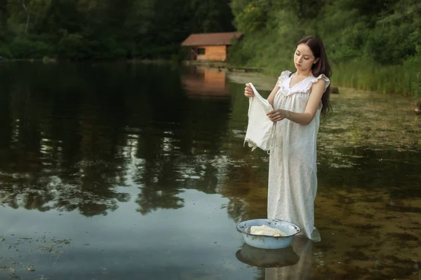 Женщина стирает одежду в реке . — стоковое фото