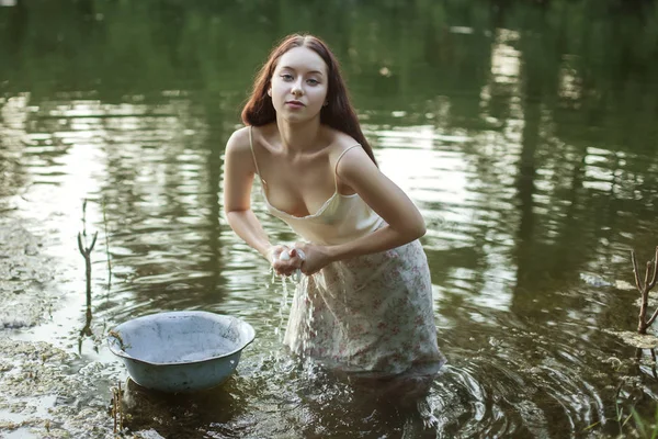 湖で洗濯物を洗う女性. — ストック写真