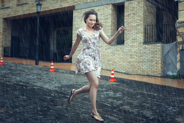 Ung kvinna springer i regnet. — Stockfoto