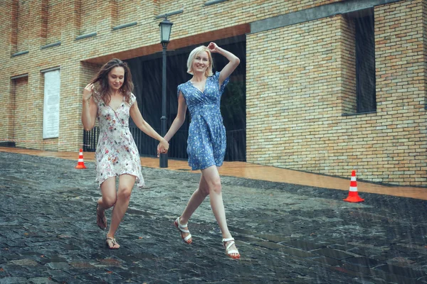 Dos novias corren bajo la lluvia . — Foto de Stock