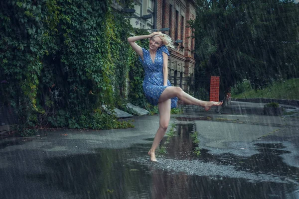 Joven mujer frolics en la lluvia de verano . —  Fotos de Stock