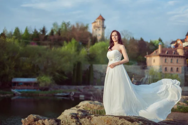 Hermosa mujer de pie junto al río . — Foto de Stock