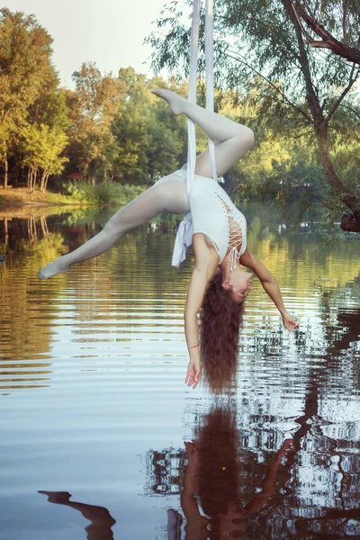 Joven acróbata chica hace trucos en lienzos . — Foto de Stock