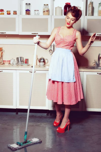 Housewife washes the floor in the kitchen.