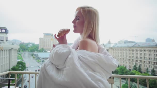 Frau Isst Morgens Auf Dem Balkon Ein Croissant — Stockvideo