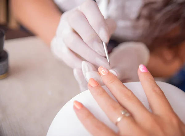 Nail care and manicure.  nails in beauty salon. Manicurist hand painting client\'s nails.