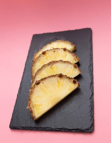 slices of pineapple fruit on a stone slab