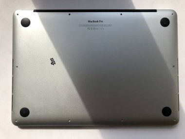 Gümüş renkli MacBook Pro 13 'ün arkası. Dizüstü bilgisayar tamir konsepti, yıkım.