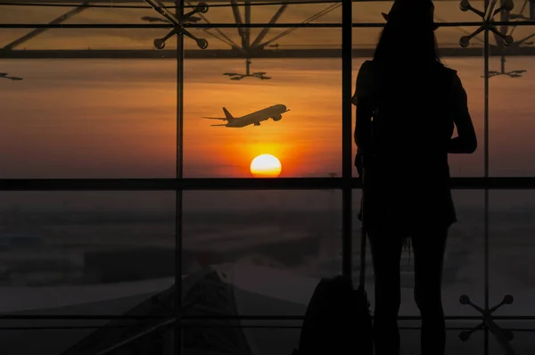Die Silhouette Einer Jungen Frau Steht Fenster Flughafen Und Beobachtet lizenzfreie Stockfotos