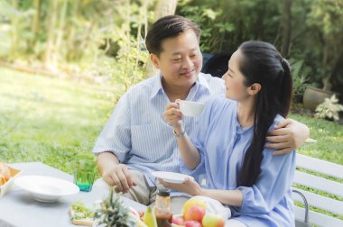 Kıdemli çift öğleden sonra çay içme bahçe dinlenmek kavram 