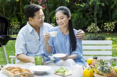 Kıdemli çift öğleden sonra çay içme kavramında bahçe dinlenmek - görüntü.