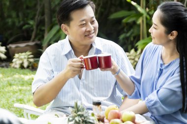 Kıdemli çift öğleden sonra çay içme kavramında bahçe dinlenmek - görüntü.
