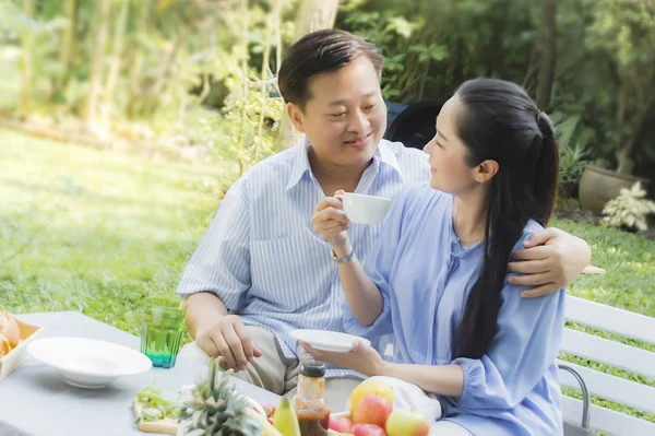Kıdemli çift öğleden sonra çay içme bahçe dinlenmek kavram 
