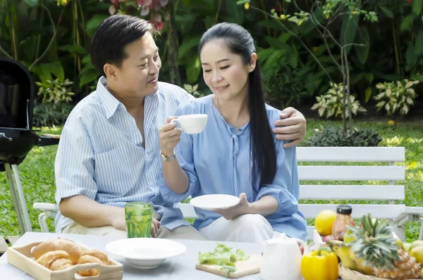 Kıdemli çift öğleden sonra çay içme kavramında bahçe dinlenmek - görüntü.