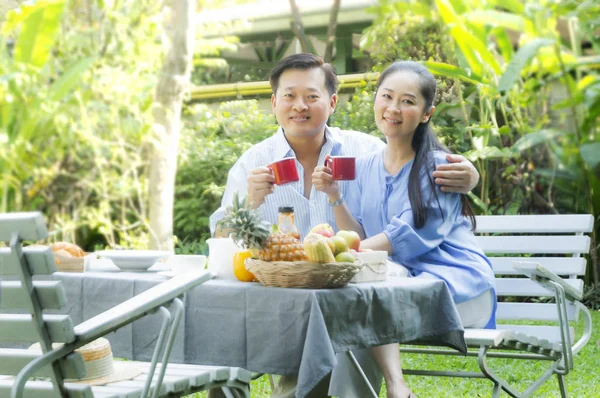 Kıdemli çift öğleden sonra çay içme kavramında bahçe dinlenmek - görüntü.