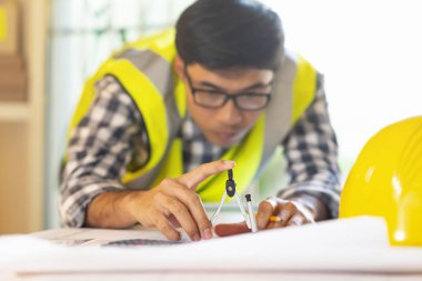 Mimar blueprint.engineer Müfettiş işyerinde - mimari proje, planları, cetvel, hesap makinesi, laptop ve bölücü pusula üzerinde çalışıyor. İnşaat kavramı. Mühendislik araçları, seçici odak