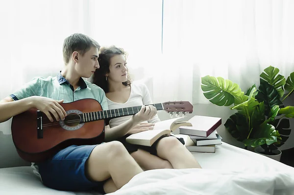 Romantico giovane coppia suonare la chitarra a letto insieme . — Foto Stock