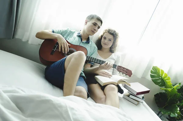 Romantico giovane coppia suonare la chitarra a letto insieme . — Foto Stock