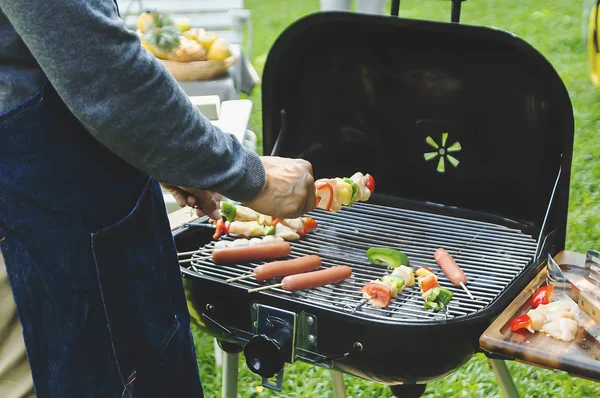 Homem cozinhar carne no churrasco para o jantar de família de verão no bac — Fotografia de Stock