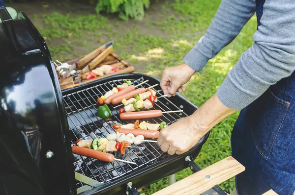 Adam içinde TZB yaz aile akşam yemeği için et mangal üzerinde pişirme