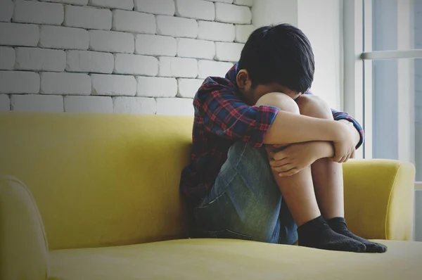 Little asiático chico triste y deprimido sentado en la habitación al lado de la —  Fotos de Stock
