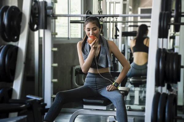 Russisk fitness kvinde med håndklæde og sund i fitnesscenter sidder på vejning - Stock-foto